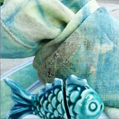 Geknotete Leinenserviette in gelb-mint mit Deko-Keramikfisch