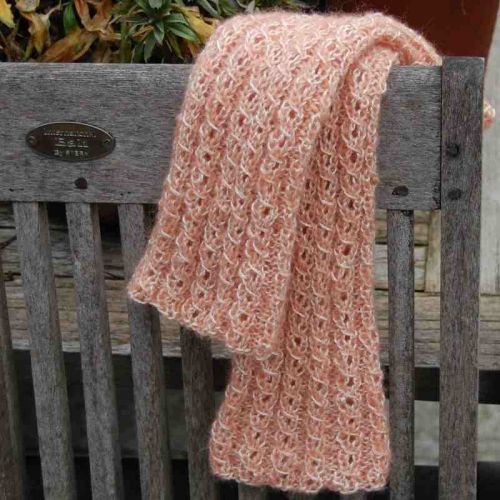 Flauschige Armstulpen aus Merino-Lace mit Mohair in Mango-Natur auf Holzstuhl