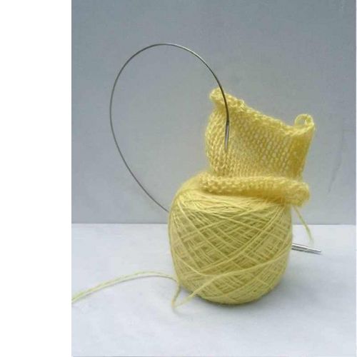 Garnknäuel und Strickprobe in pflanzengefärbtem Gelb