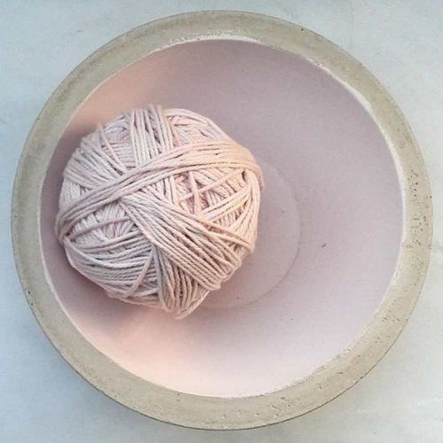Baumwollknäuel in zartem Rosa in Beton-Schüssel