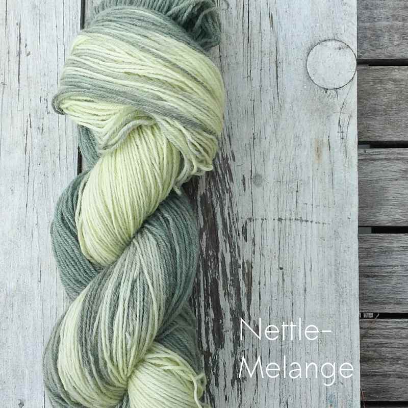 Vollbild Pflanzengefärbtes Sockengarn in Gelb-Grün-Mischung, auf altem Holzbrett