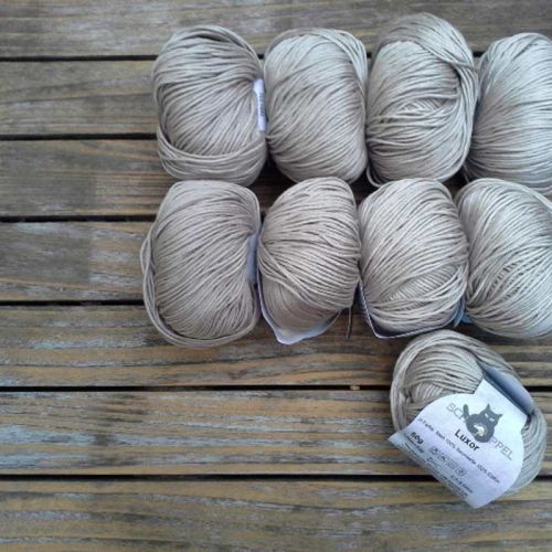 9 Knäuel Baumwollgarn Luxor in der Farbe Stein auf Holztisch