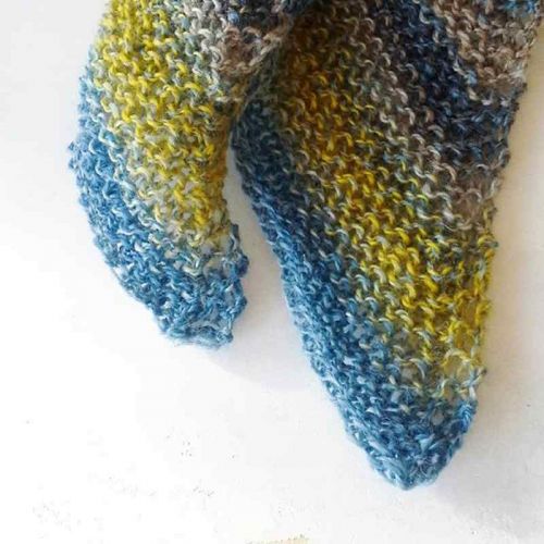 Zipfel eines kraus rechts gestrickten Schals aus Crazy-Zauberball in gelb-blau