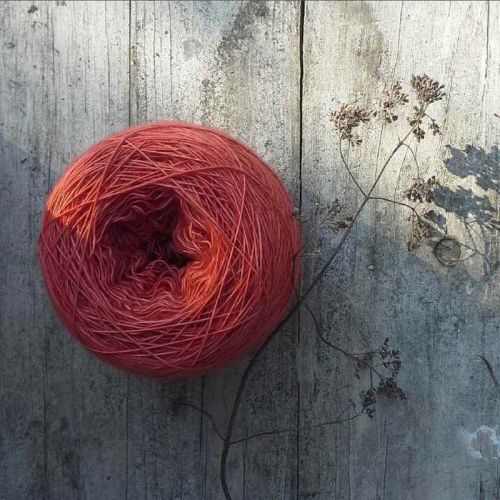 Ein Knäuel rotes Strickgarn pflanzengefärbt